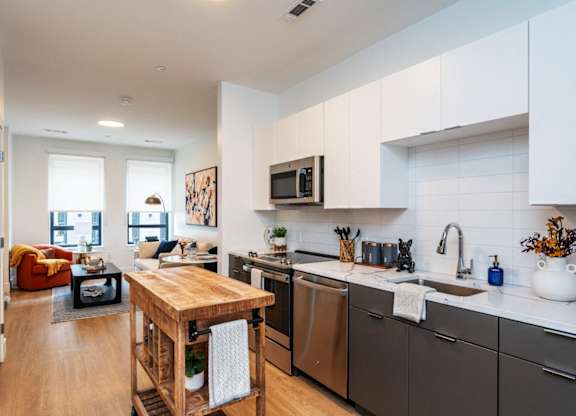 A modern kitchen with a wooden island and stainless steel appliances.