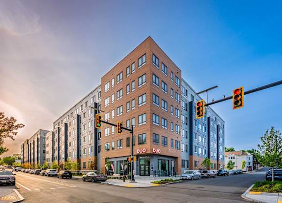 A street view of a multi-story building with a red brick facade and a sign that reads "DIO".