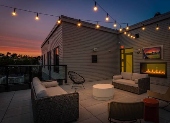 A patio with a fireplace and chairs.