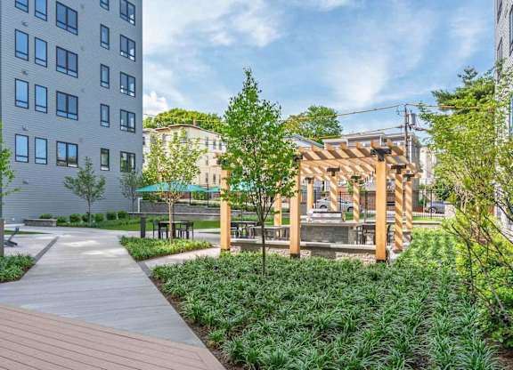 A wooden deck leads to a pavilion in a city park.