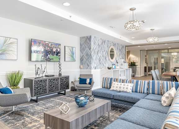 Parkside Commons community room with a grey armchair, a wooden coffee table, and a blue sofa.