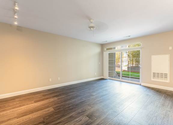 Parkside Commons vacant apartment room with wooden flooring and a ceiling fan.