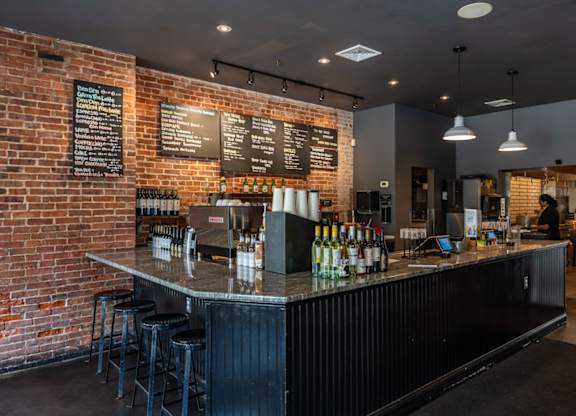 A bar with a black counter and a brick wall.
