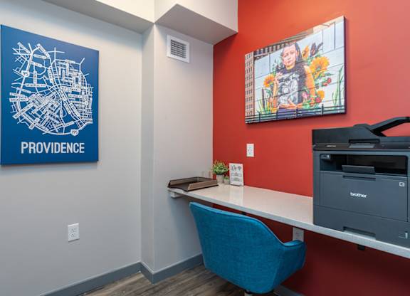 A blue chair sits in front of a Providence map on a wall.