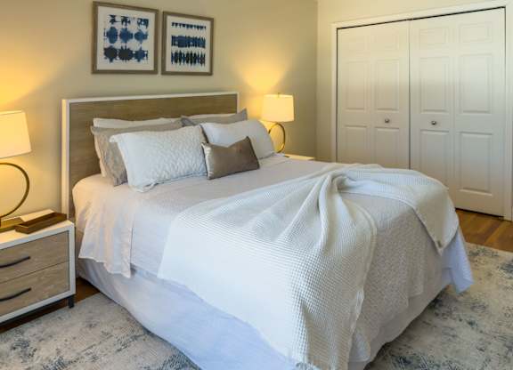 A bed with a white blanket and pillows is in the image.