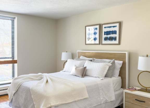 A bedroom with a large bed and a blue patterned rug.