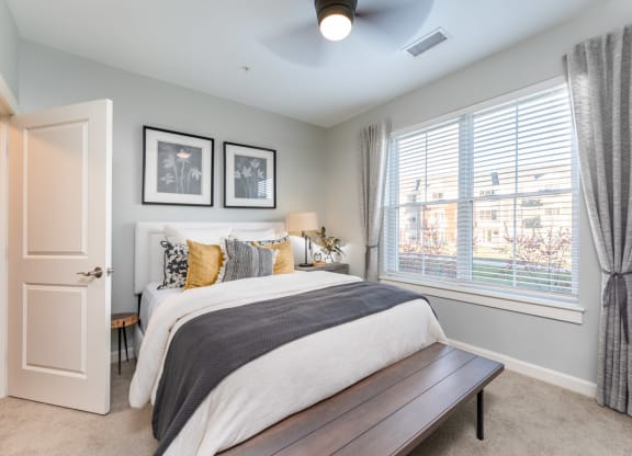 model bedroom with plush carpeting and ceiling fan