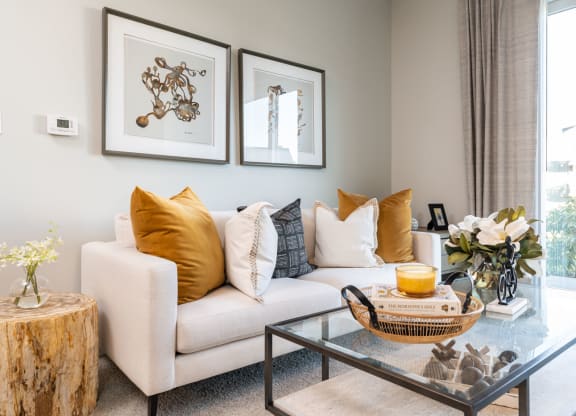 Model apartment common space couch with coffee table and paintings