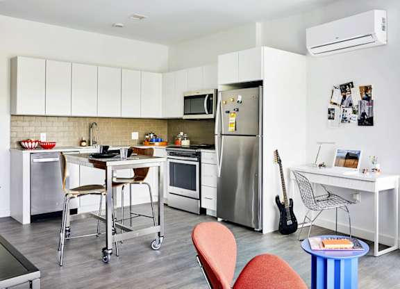 A modern kitchen with a dining table and chairs, model apartment