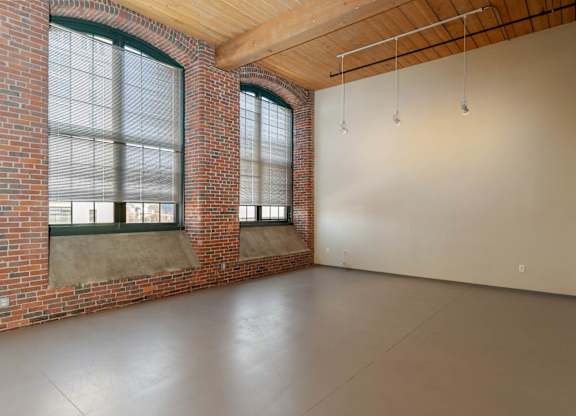 A large empty room with brick walls and a concrete floor.