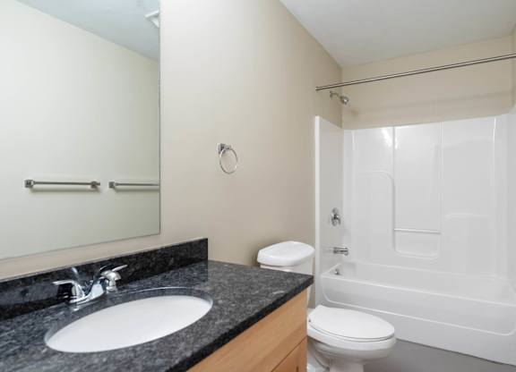 A bathroom with a sink, toilet and bathtub.