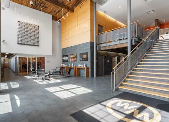 A large open space with a staircase and a table with chairs.