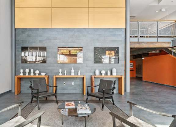 A room with a grey table and chairs with a wall in the background.