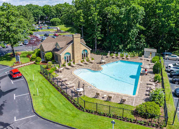 an aerial view of a swimming pool in front of a house