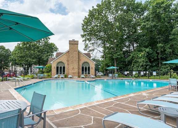 a swimming pool with chairs and umbrellas at the resort