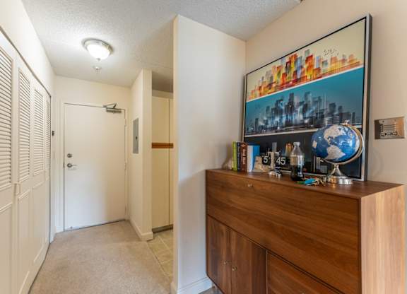a hallway with a dresser and a door to a closet and a hall way