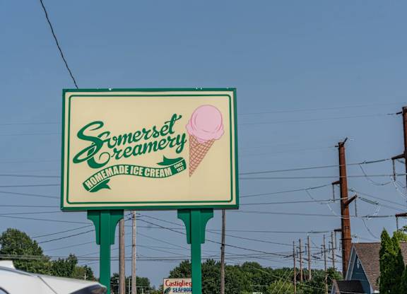 Somerset Creamery roadside sign with an illustrated pink ice-cream cone and green script lettering.