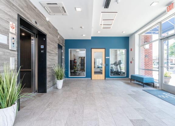 a large lobby with a bench and glass doors
