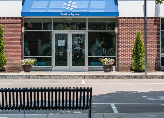 a bench in front of a building with a blue awning