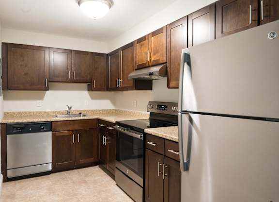 a kitchen with dark wood cabinets and stainless steel appliances