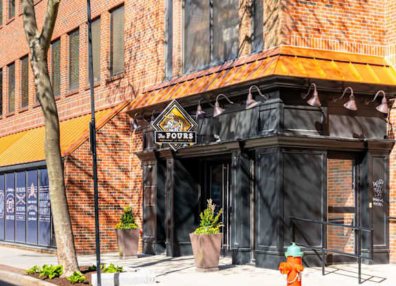 A building with a black awning and a fire hydrant in front of it.