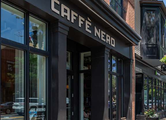 a coffee shop on the corner of a city street "Cafe nero"
