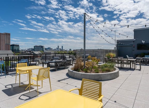 a rooftop patio with tables and chairs and a city in the background  at Union 346, Somerville, MA 02143