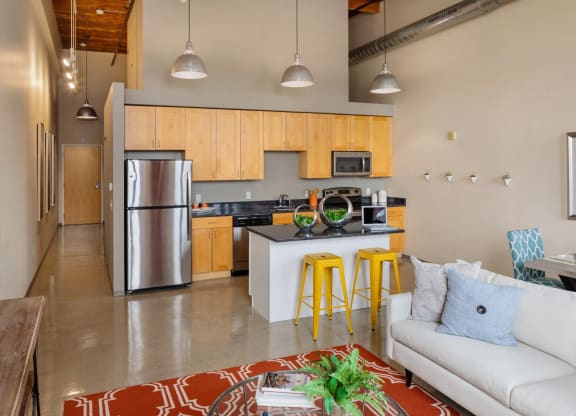 a kitchen with stainless steel appliances and wooden cabinets in a living room