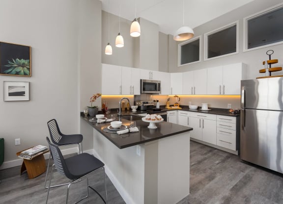 a kitchen with an island and a stainless steel refrigerator