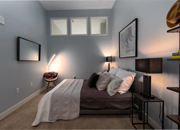 a bedroom with blue walls and a bed with pillows
