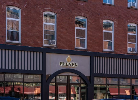 the front of a store with a sign on the side of a brick building