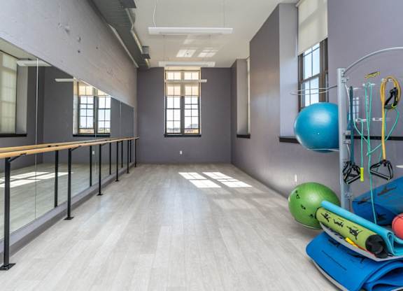 a fitness room with yoga equipment and mirrors at the 240 building