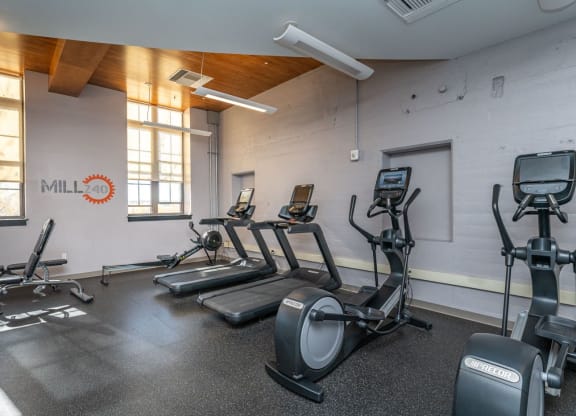 a gym with treadmills, bench, ellipitcals,  and other exercise equipment