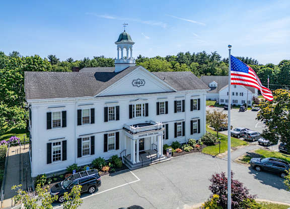 A white building with a green dome and an American flag on top.