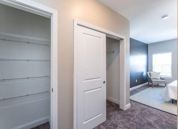 A white closet with shelves and a white door.
