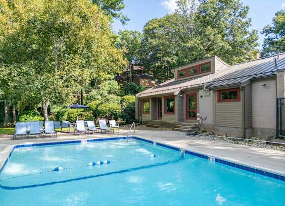 a swimming pool in front of a house with a pool