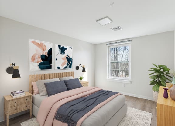 a bedroom with a bed and paintings on the wall at Shoreline Grove Apartments in Branford CT.