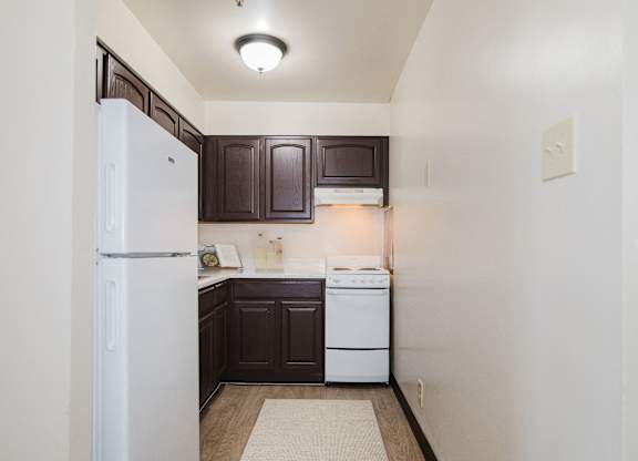A small kitchen with a white refrigerator and a white dishwasher at Branchwood Towers, Clinton