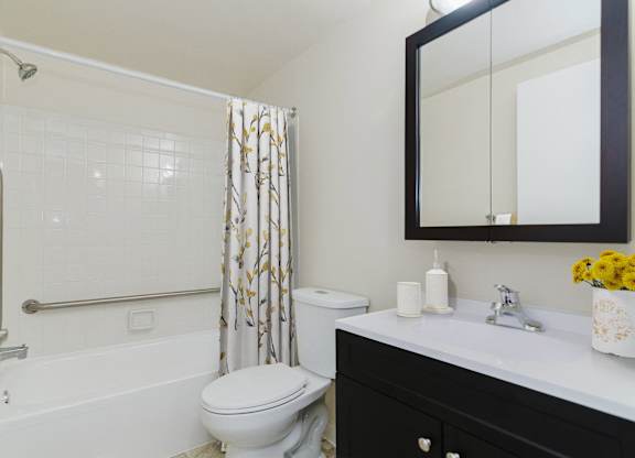 A white toilet sits in a bathroom next to a sink and a shower at Branchwood Towers, Clinton