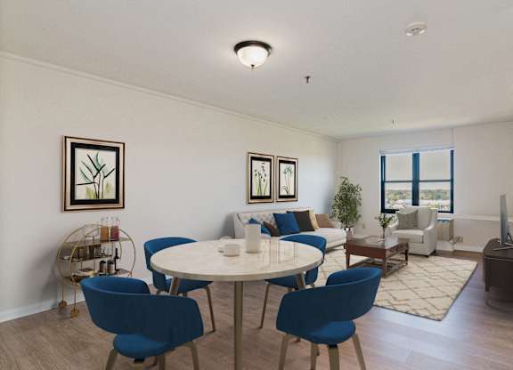A dining room with a white table and blue chairs at Branchwood Towers, Clinton
