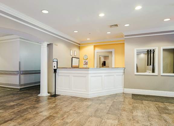 A reception area with a white counter and a framed picture on the wall at Branchwood Towers, Clinton