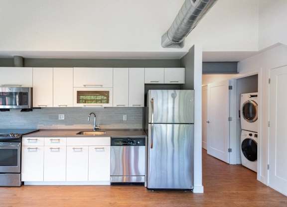 a kitchen with white cabinets and stainless steel refrigeratorat Ames Shovel Works Apartments, Massachusetts, 02356