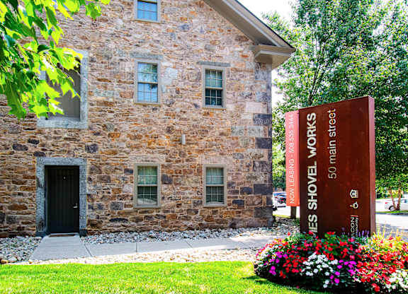 a stone building with a sign in front of itat Ames Shovel Works Apartments, North Easton, MA, Massachusetts