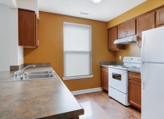 a kitchen with white appliances and wooden cabinets at Waterfront Apartments, Buffalo, NY