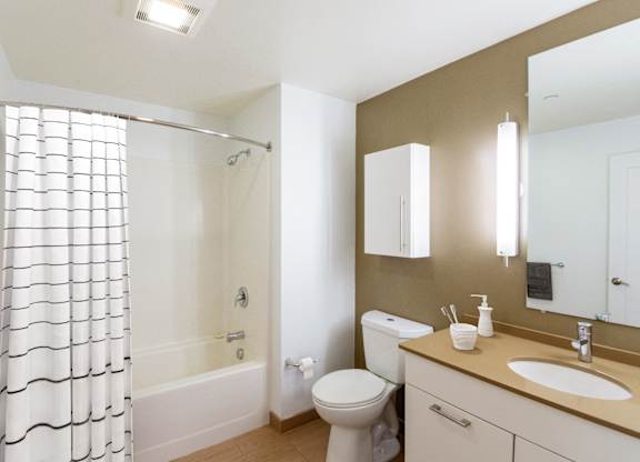 a bathroom with a shower and a sink and a toiletat Ames Shovel Works Apartments, North Easton, MA, 02356
