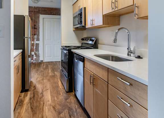 A kitchen with wooden floors and white walls at Brewery Square Apartments, Connecticut, 06513