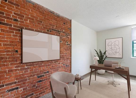 A room with a brick wall and a wooden table with a plant on it at Brewery Square Apartments, New Haven , CT, 06513