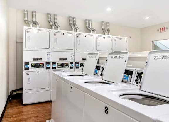 A row of washing machines are lined up in a laundromat at Brewery Square Apartments, New Haven