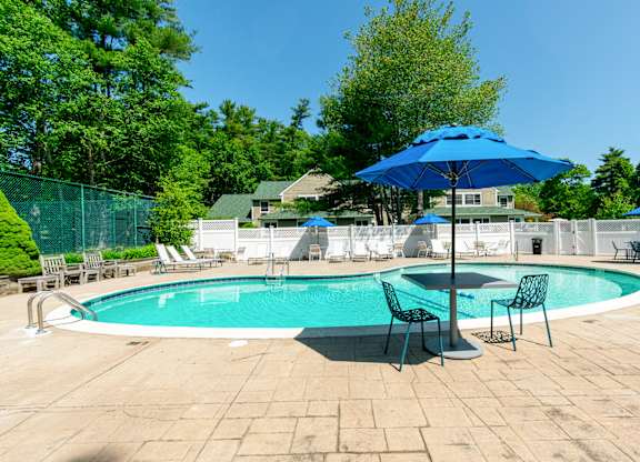 A blue umbrella is next to a pool table at at Mariner's Hill Apartments, Massachusetts.