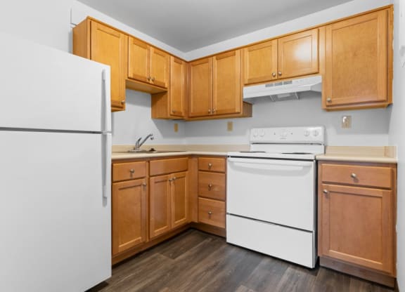 Kitchen Layout With Wood Cabinets And White Appliances  at Belvedere Acres Apartments, Washington, 15301